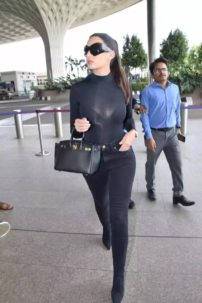 Nora Fatehi teams all-black top and leather pants with boots and